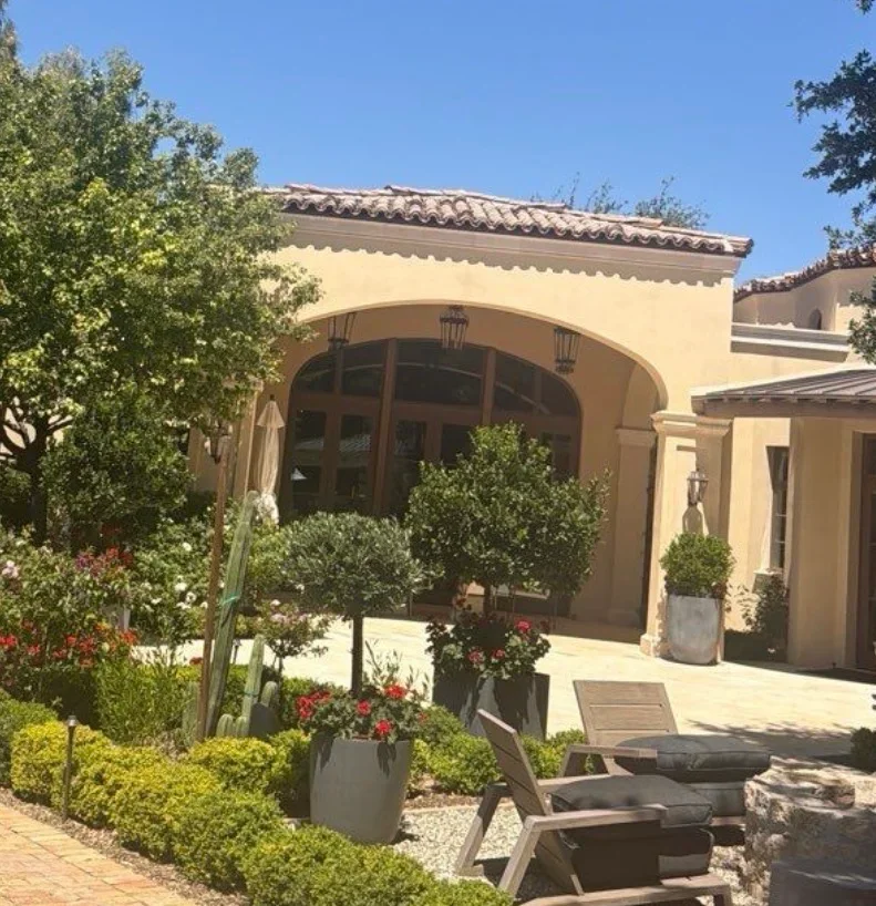Spanish clay barrel tile roof with ridge cap on arched entry, residential home exterior