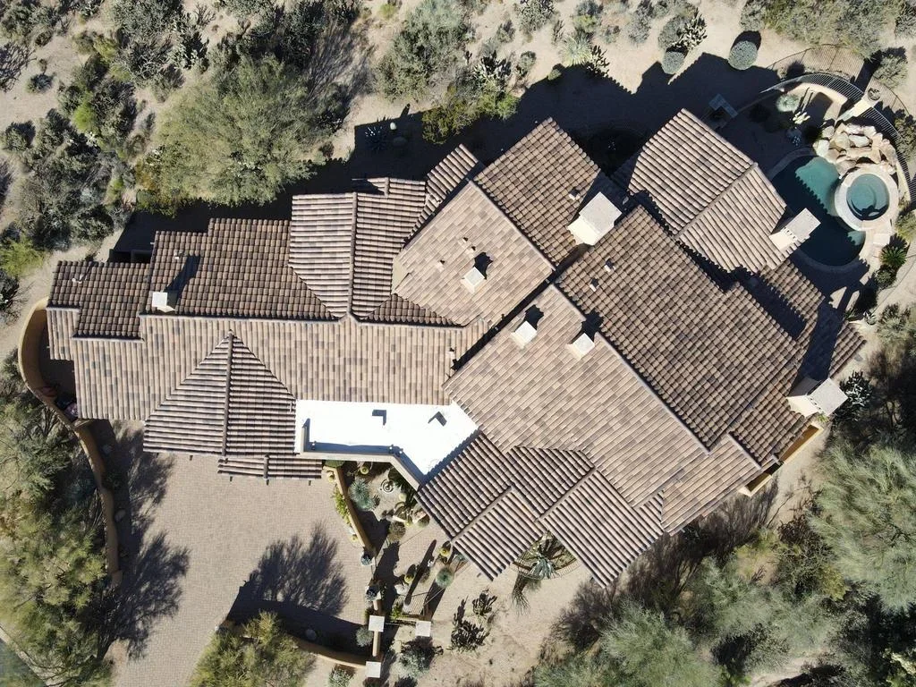 Aerial view of multi-slope residential roof with dimensional shingles, multiple peaks, and complex roof transitions