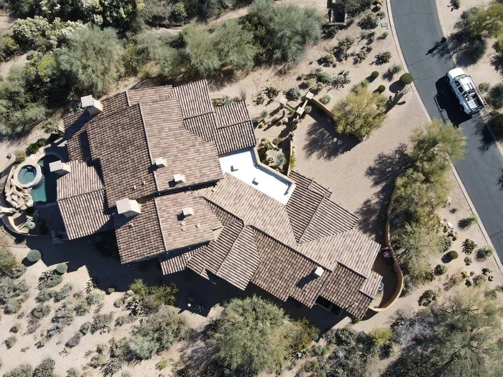 Aerial view of residential roof with composite shingles installed on multi-level structure