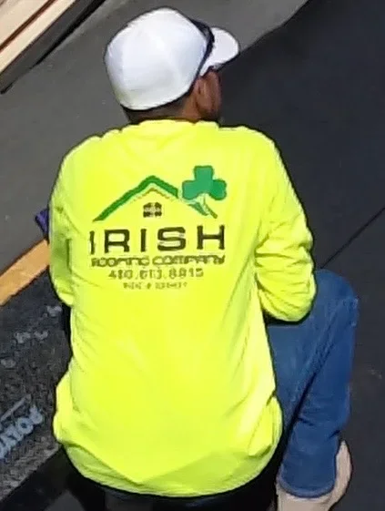 Roofing contractor in safety gear on active job site installation