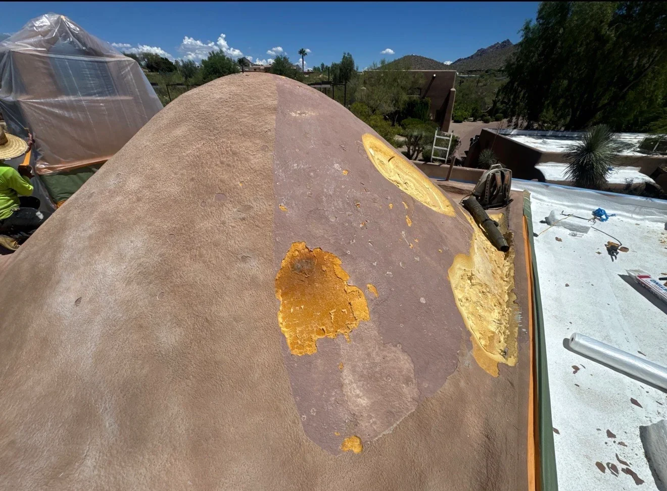 Dome roof with yellow primer patches and removal areas during repair and restoration work