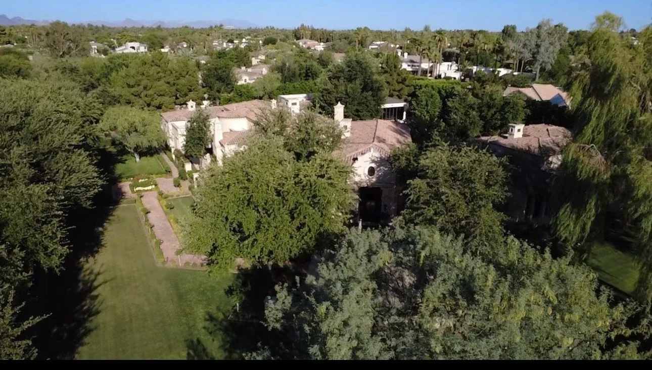 Aerial view of clay tile roof on residential estate with mature trees and landscaped grounds
