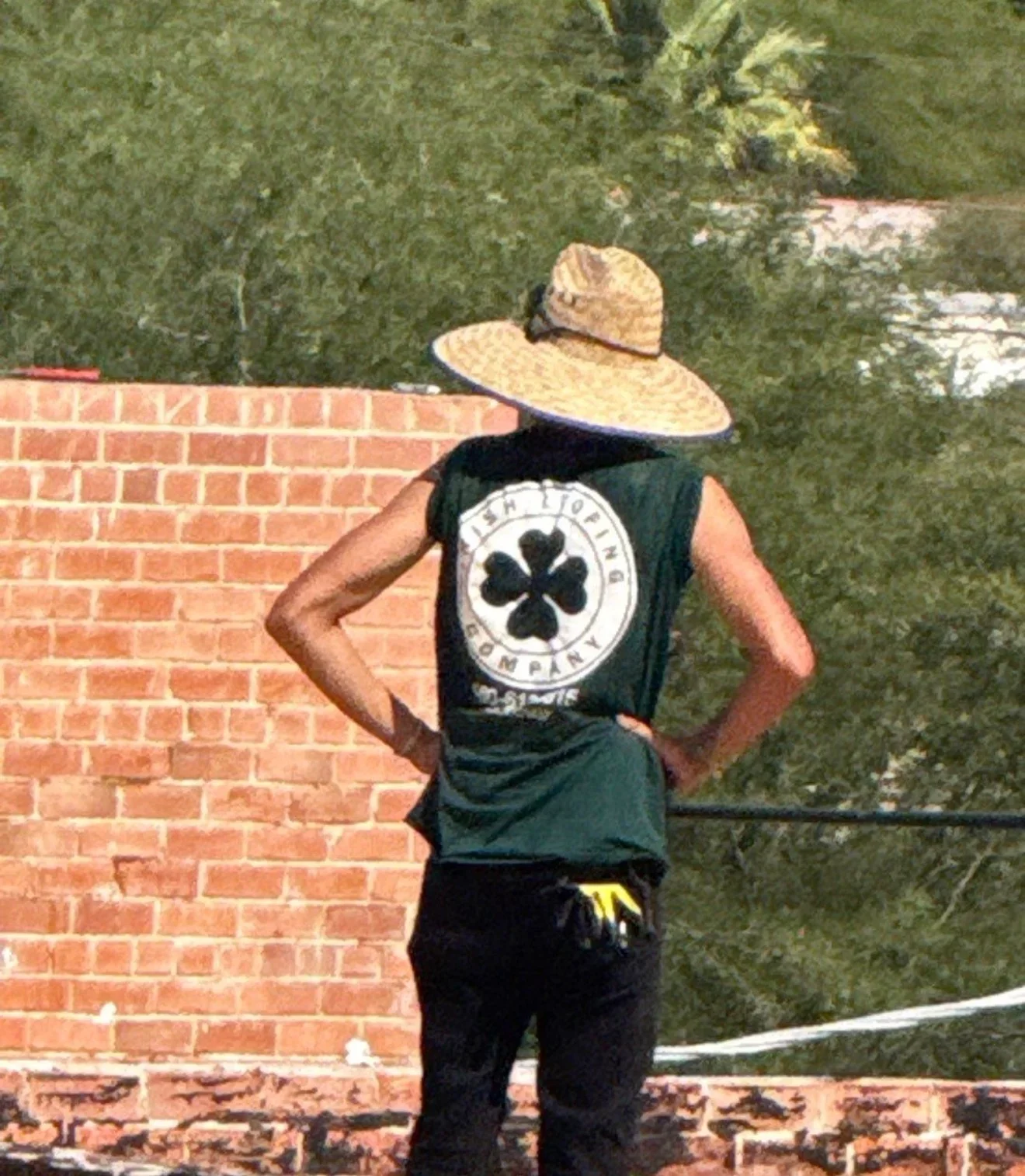 Worker inspecting brick chimney and roof flashing on residential property