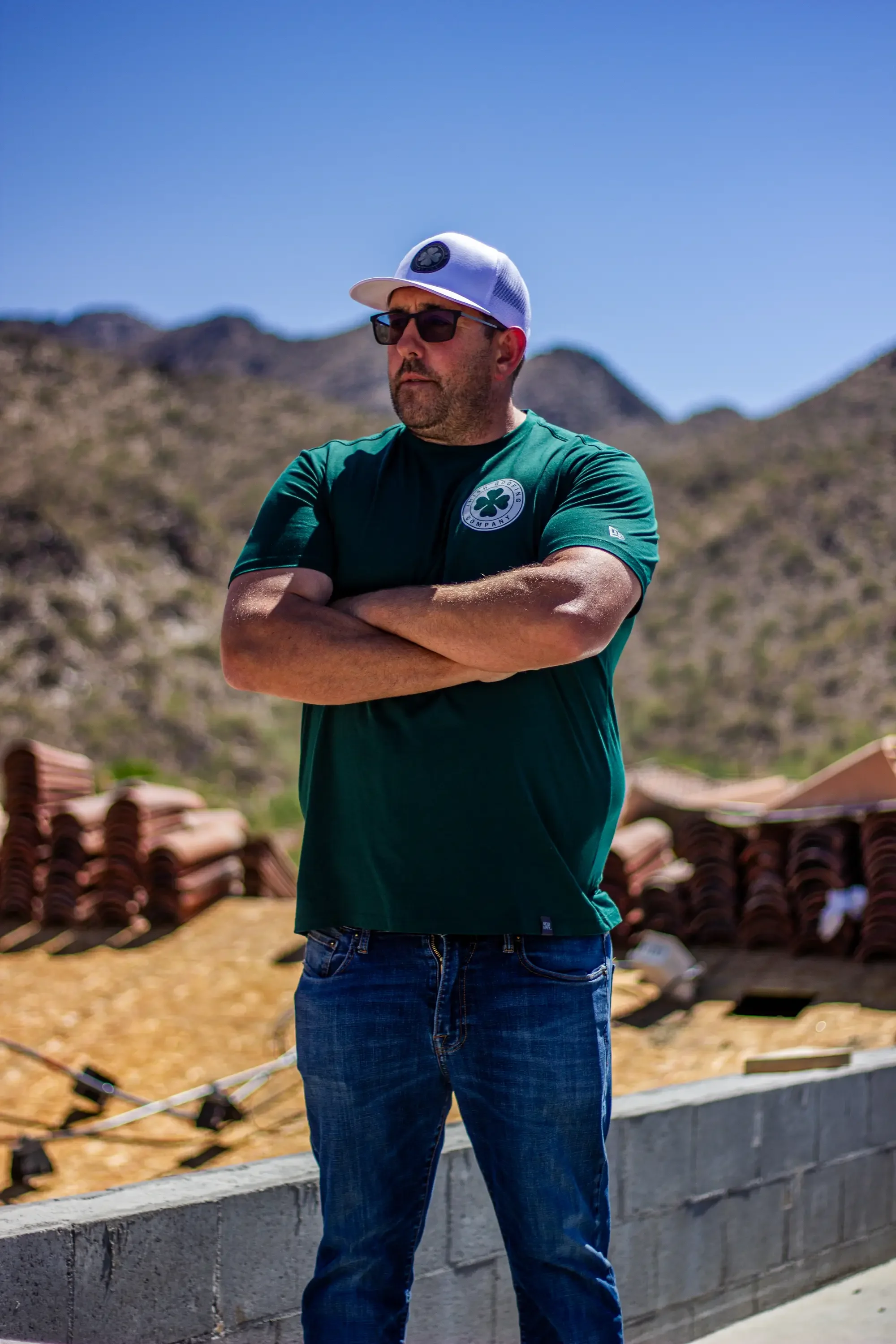 Concrete foundation and roofing materials staged at residential construction site