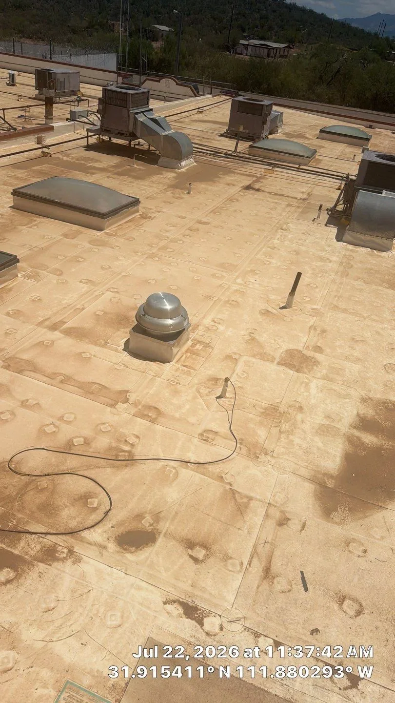 Tan membrane flat roof with dome skylights, HVAC units, and drainage penetrations installed