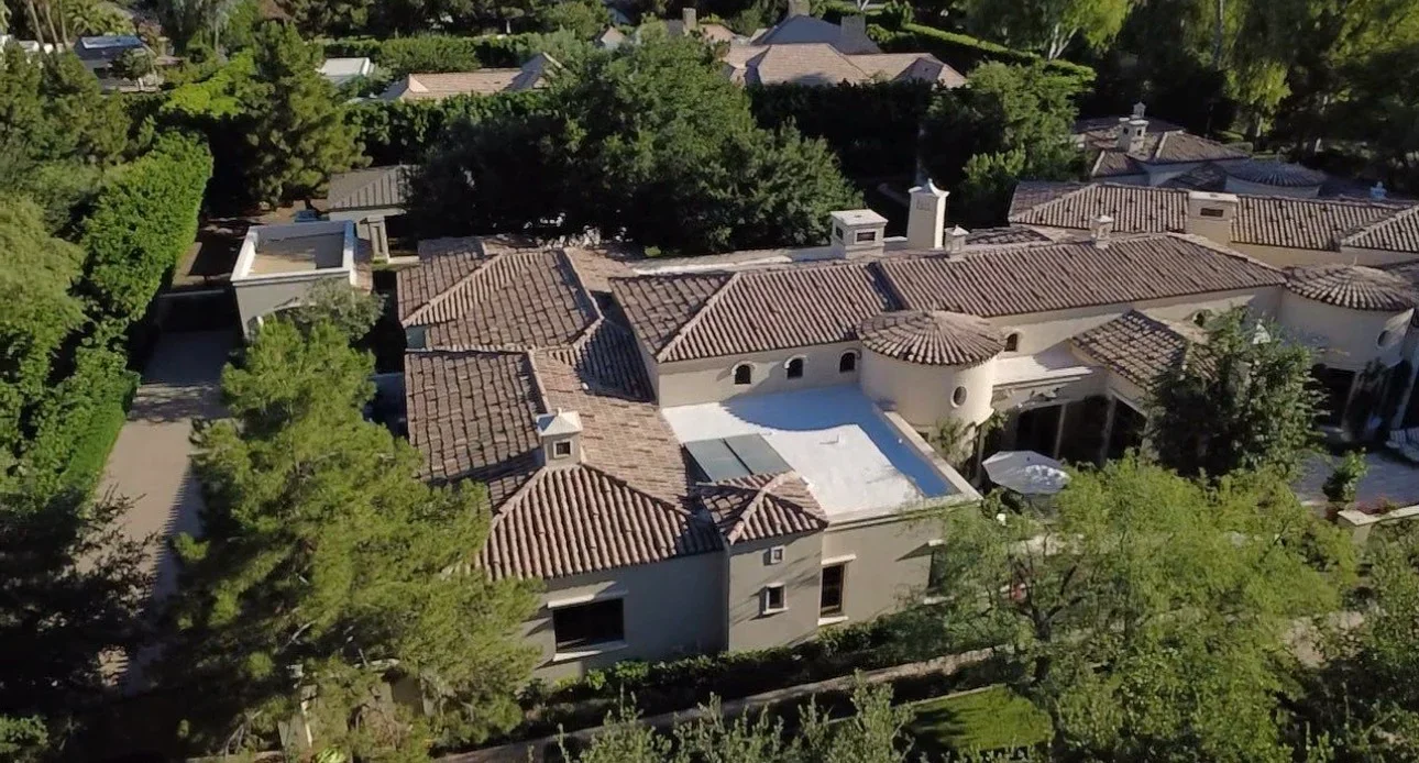 Aerial view of residential roofs with clay barrel tiles, multiple peaks and valleys, terracotta finish