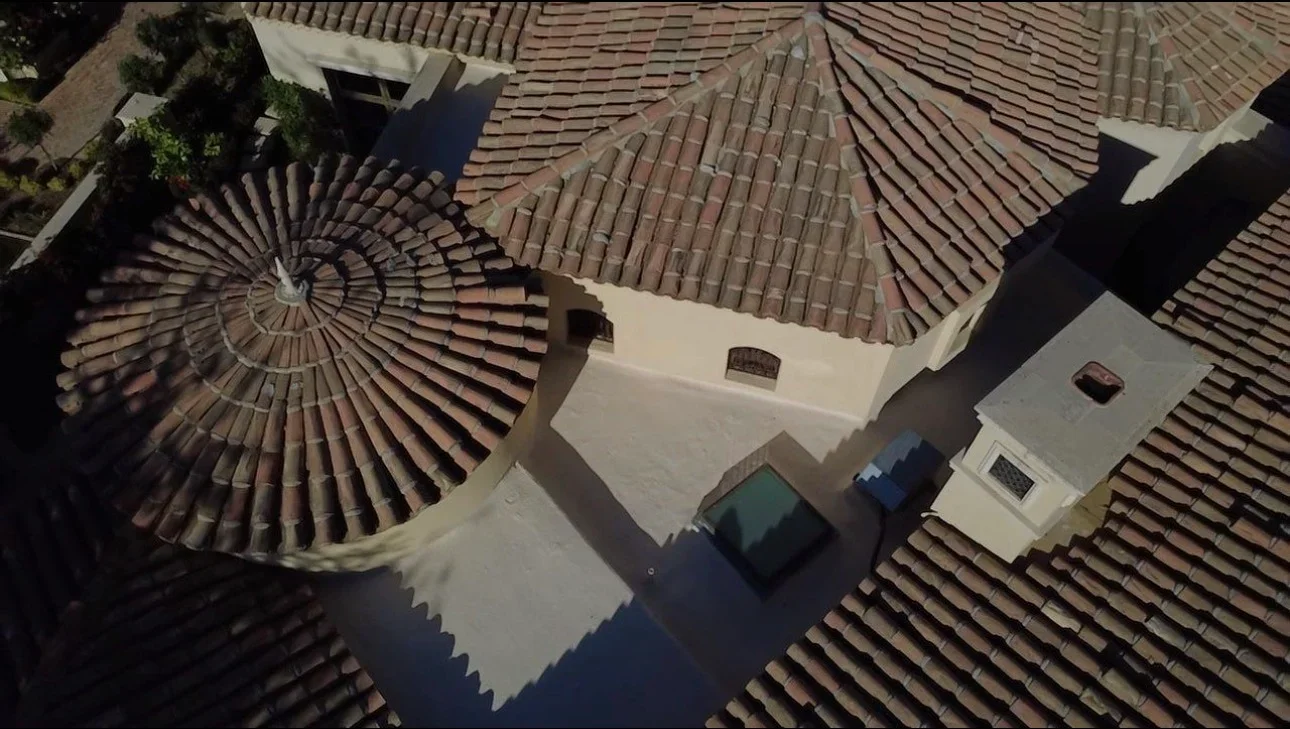 Aerial view of clay tile roof with barrel and flat tiles, cream fascia, and multiple roof planes