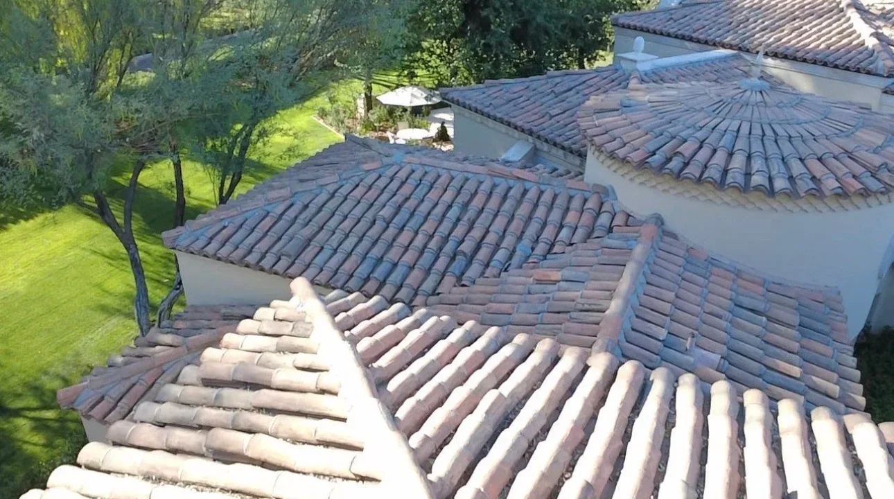 Spanish clay barrel tile roof with multiple sections, hip and valley details, terracotta tiles on white walls