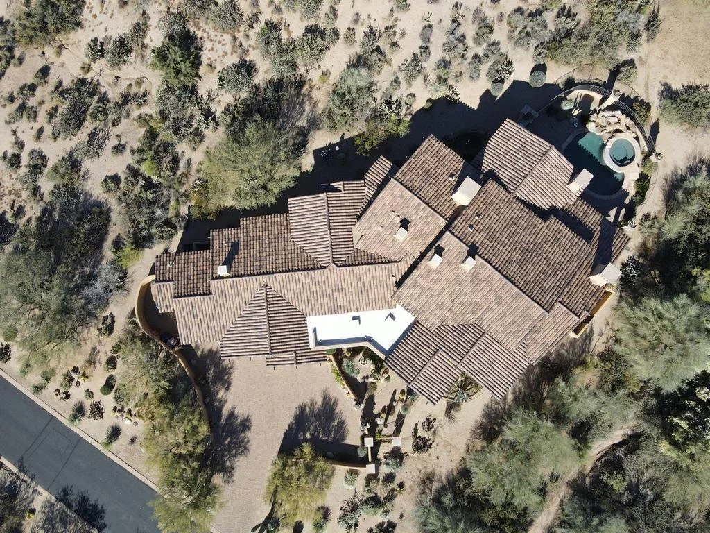 Aerial view of multi-section residential roof with clay tile installation and complex roofline design