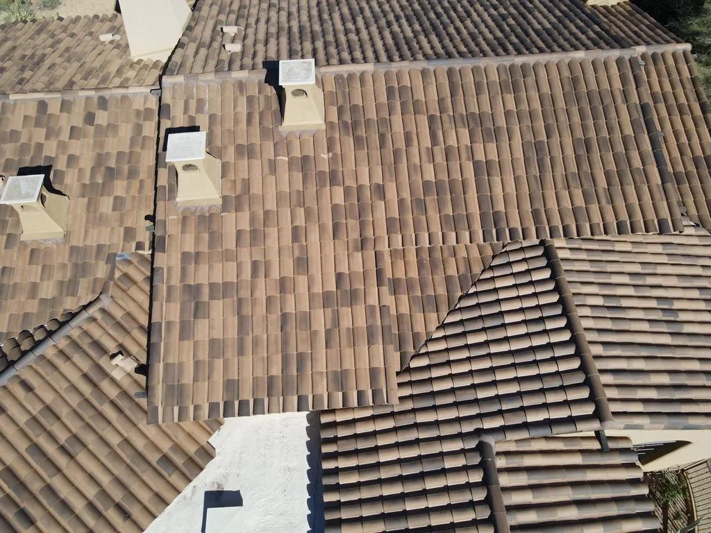Aerial view of clay tile roof installation with multiple sections and roof vents