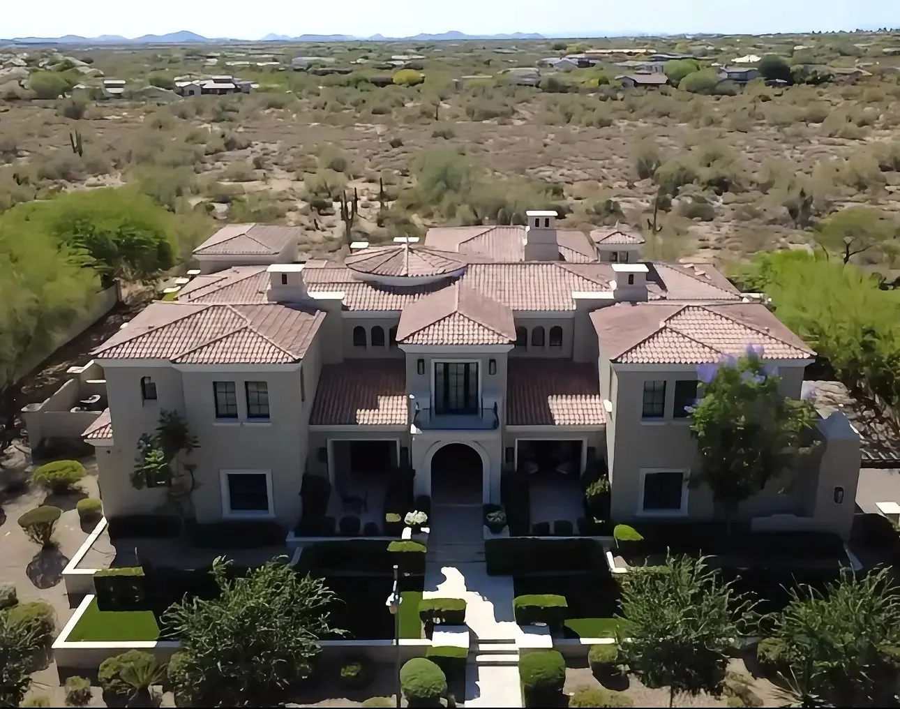 Spanish Colonial estate with clay barrel tile roof, multiple gables, and cupolas
