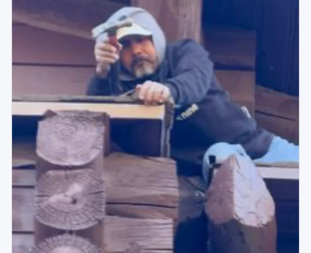 Roofer installing cedar shake shingles on residential roof using hammer and nails