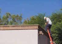 Roofer working on clay tile and concrete roof sections with ladder access