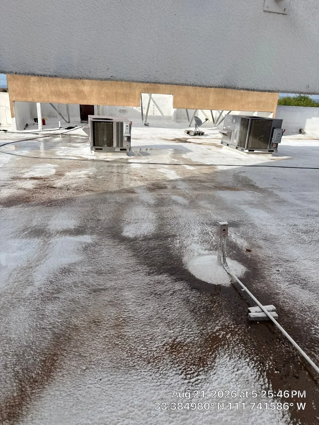 Flat roof installation with two HVAC units, drainage system, and concrete deck preparation