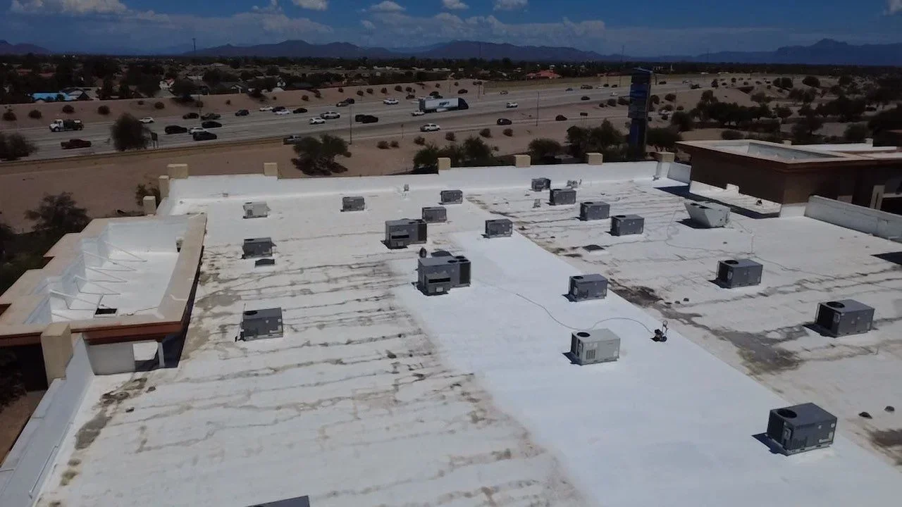 White membrane flat roof with HVAC units and roof penetrations on commercial building