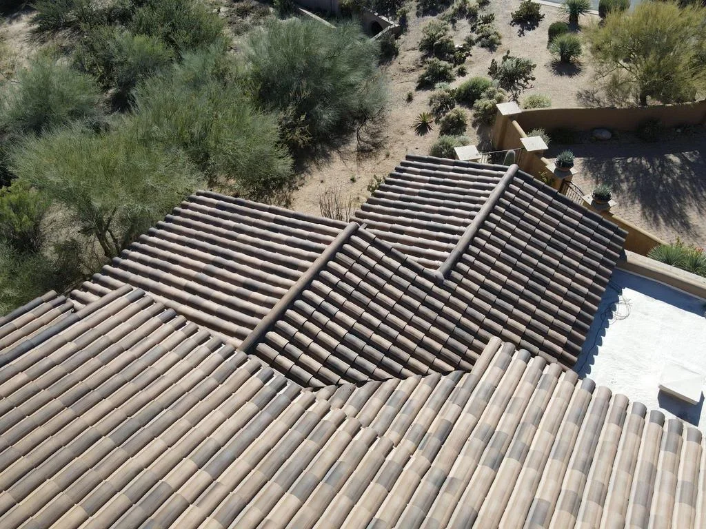 Multi-pitch clay tile roof installation with barrel tiles and integrated drainage system
