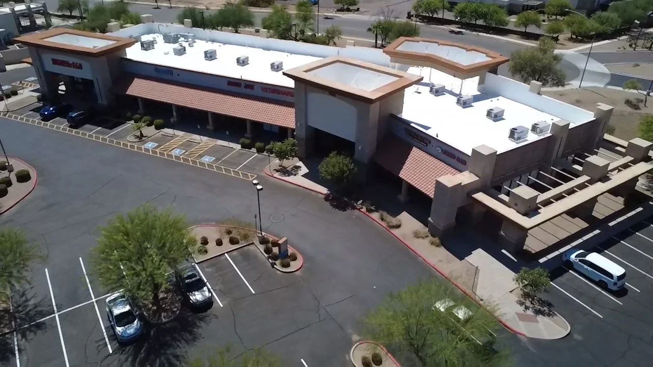 Commercial flat roof with white TPO membrane, HVAC units, and copper trim details