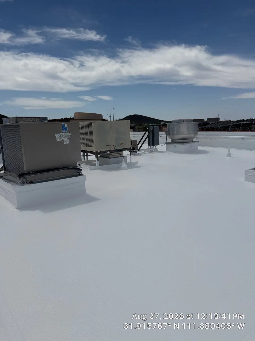 White membrane flat roof with HVAC units, flashing, and equipment curbs installed