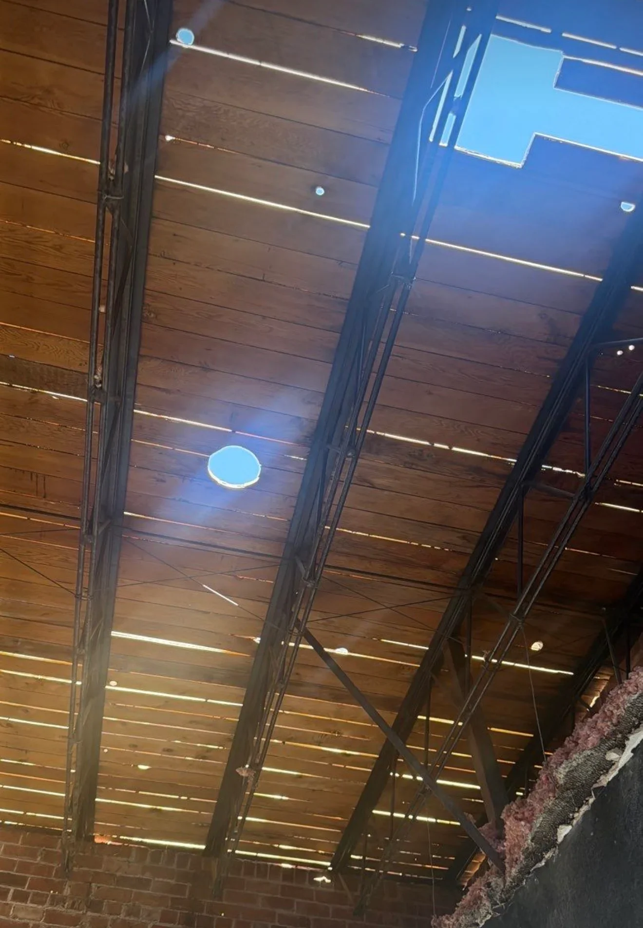 Wooden plank ceiling with integrated linear LED lighting and steel support beams