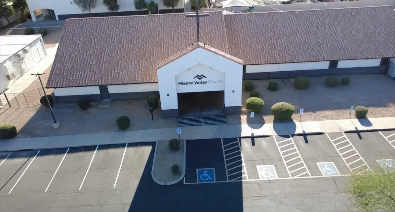 Aerial view of commercial building with new charcoal gray asphalt shingle roof and copper flashing