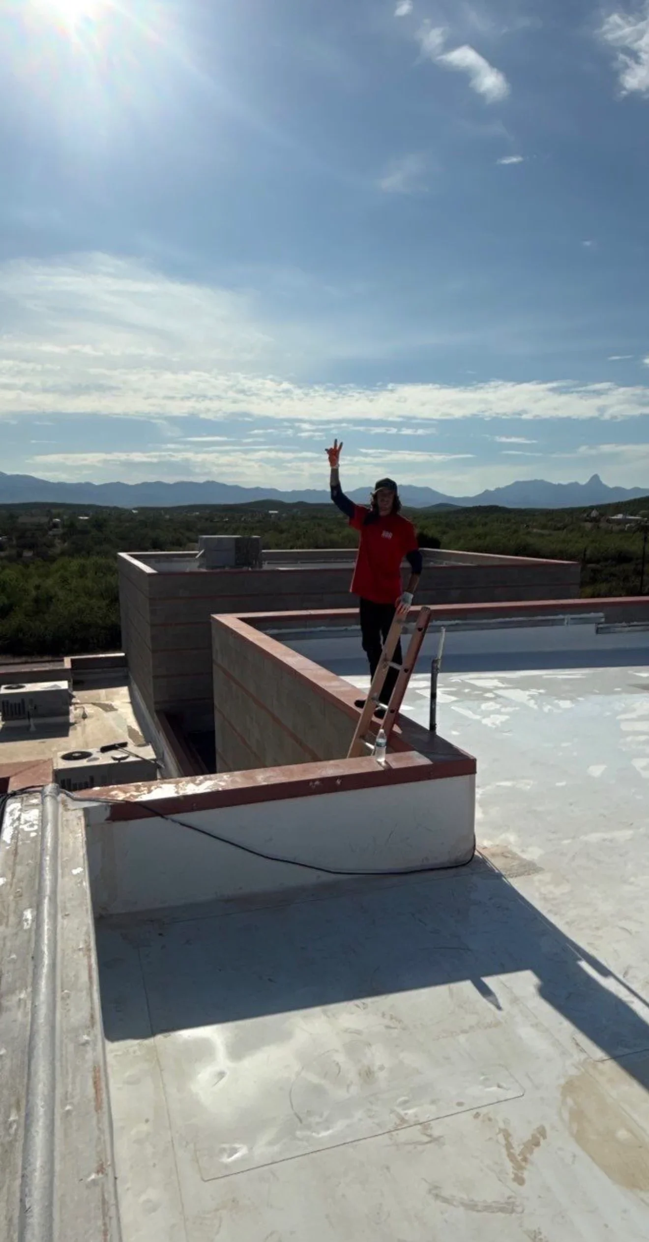 Flat roof membrane installation with parapet walls and metal coping trim on residential structure