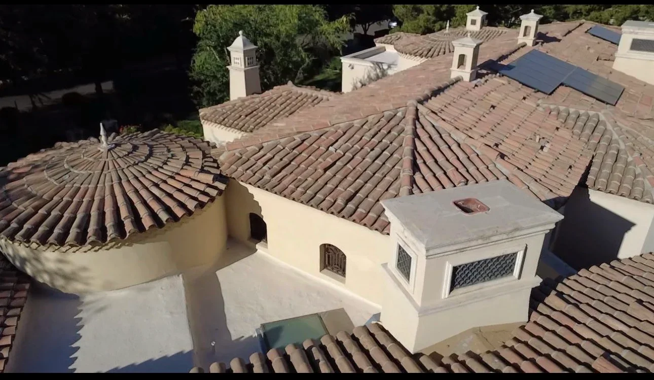 Aerial view of Spanish clay tile roof installation with cupola and ridge caps on residential structure