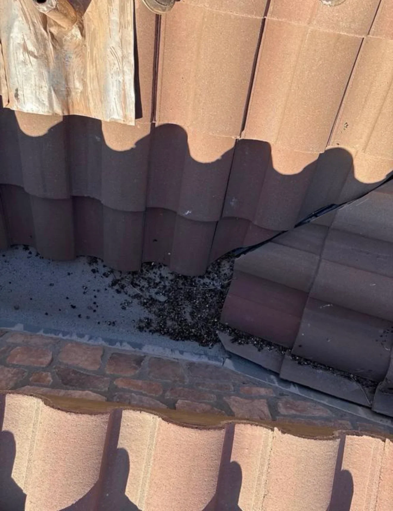Clay barrel tiles in terracotta and brown installed with proper overlap and underlayment visible at eave