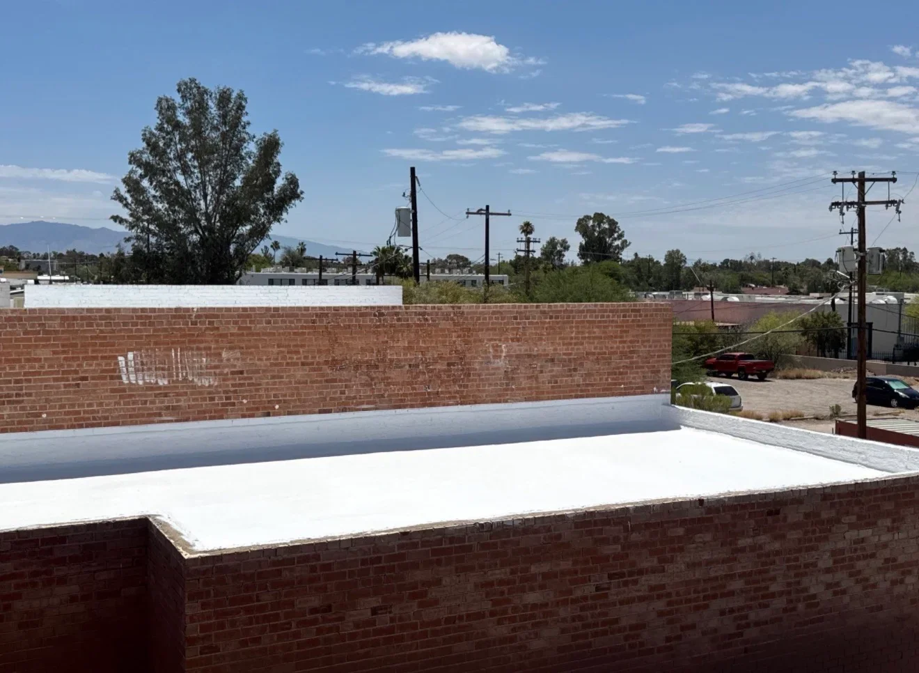 White membrane flat roof installed on brick commercial building with parapet walls
