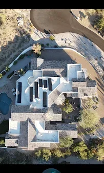 Aerial view of modern home with dark shingle roof installation on multiple planes