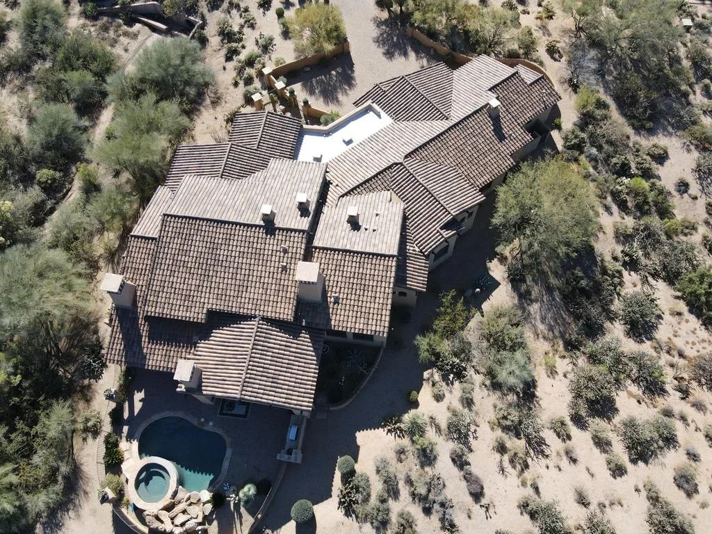 Aerial view of residential roof with clay tile and standing seam metal roofing sections